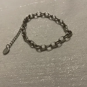 Silverfärgat armband  - Elegant silverfärgat armband  med justerbar kedja.  Perfekt för att ge en stilren touch till din outfit.