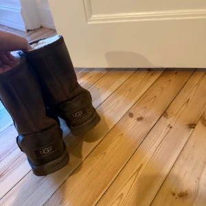 UGGS  - Säljer ett par klassiska bruna UGG boots med mjukt foder. Perfekta för kalla dagar med sin varma och bekväma design. Har salt fläckar på sig men det går bort om man putsar dem.