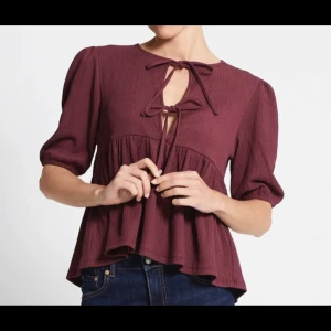Vinröd blus med knytning - Snygg vinröd blus med knytning framtill och trekvartsärmar. Helt ny och Prislappen sitter kvar🤗