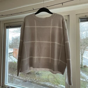 Beige rutig stickad tröja - Säljer en mysig beige stickad tröja med rutigt mönster. 