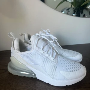 Vita Nike Air Max sneakers - Snygga vita Nike Air Max sneakers med en luftig design och synlig luftkudde i hälen för extra komfort. Skorna har snörning och en modern look som passar perfekt för en sportig stil.