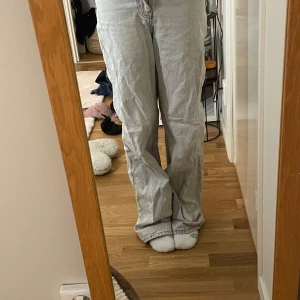 Grå jeansbyxor från Zara - Säljer ett par grå jeansbyxor från Zara med en avslappnad passform. Byxorna har en klassisk design med raka ben. Säljer pga att de är lite för små i midjan men är lite för långa vid benen på mig som är 167