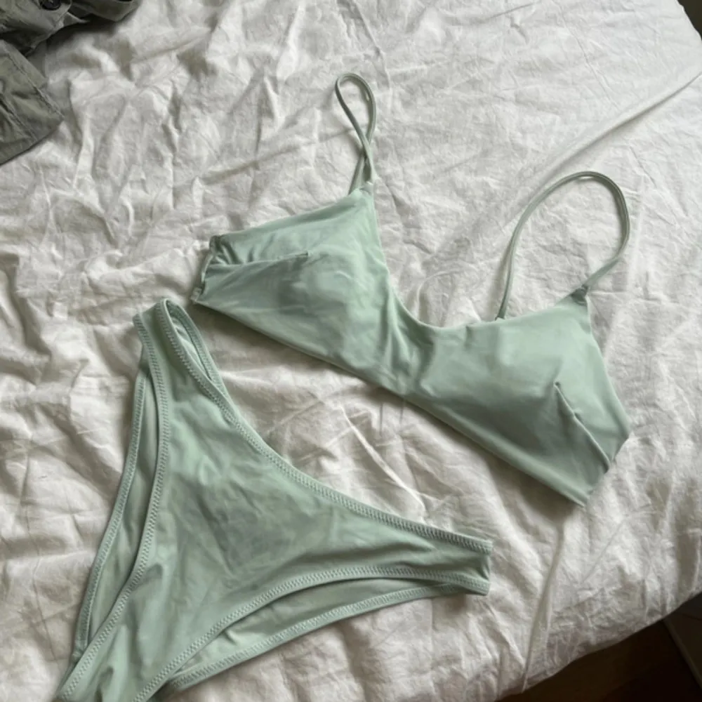 Snygg ljusgrön bikini med enkel design. Toppen har smala axelband. Perfekt för en dag på stranden eller vid poolen.. Muu.