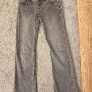 Grå bootcut jeans med stjärndetalj - Fina gråa bootcut low waist jeans med en stjärndetalj, dessa är super fina och jag säljer de på grund av att de är för korta för mig. De är från Gina Young och är i storlek 158 tall
