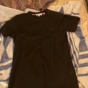 Svart ÄKTA Moncler T-shirt - Säljer en stilren svart ÄKTA moncler t-shirt med rund hals och korta ärmar.