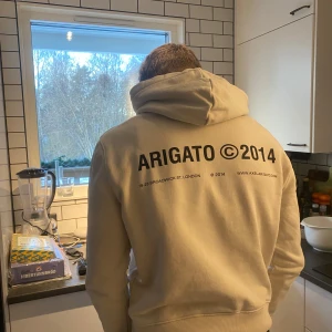 Beige/Vitt hoodie från Axel Arigato - Jag säljer denna snygga Arigato Hoodien då jag växt ut den, mycket sparsamt använd därför har hoodien inga defekter. Hör av er vid yttligare frågor!😇