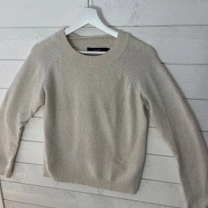 Beige stickad tröja - Mysig beige stickad tröja med rund hals och långa ärmar. Perfekt för kyliga dagar och enkel att matcha med olika outfits.