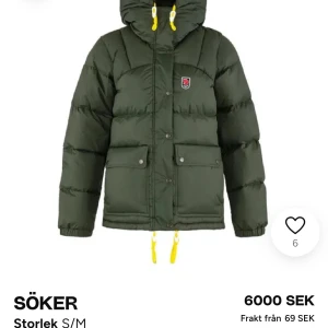 Söker grön fjällräven jacka  - Söker en grön dunjacka från Fjällräven med huva och gula detaljer. Jackan har långa ärmar och praktiska fickor med knappar framtill. Perfekt för kyliga dagar.