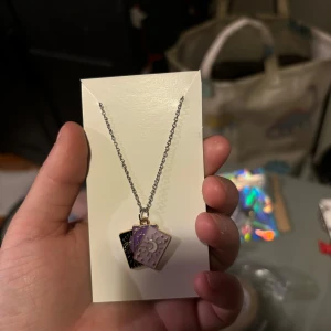 Halsband med tärningshänge - Snyggt halsband med ett unikt tärningshänge i silver och svart. Perfekt för att ge en lekfull touch till din stil. Kedjan är i silverfärg och hängsmycket har en fin detalj med siffran fem.