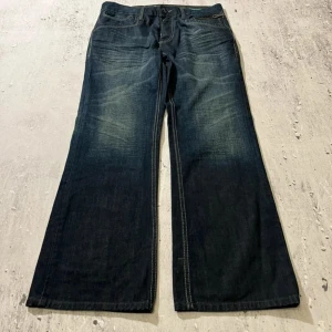 Coola Bootcut jeans - Snygga bootcut jeans i mörkblå denim.                  Midja:43cm. Längd:103. Benöppning:25. Lår:28