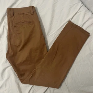 Bruna Matinique chinos - Mycket fina och eleganta chinos i brun färg från Matinique. Byxorna är så pass oanvända att fickorna där bak är ännu inte uppklippta. Stilrena och snygga. Minns ej vilken storlek de var exakt så därför följer mått nedan.  Midja: 40cm Längd: 101cm Benöppning: 75cm. Kan gå med på nån deal, skicka iväg ett pris/fråga!