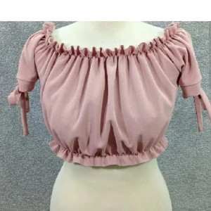 Off shoulder top - Färgen motsvarar första bilden (dusty pink/gammelrosa). Band vid midjan och runt axlarna vid ruschet så den sitter på plats. Snörning till rosett vid armarna. Från New Look i stl 34. Enstaka ställen vid ruschet har töjts ut men inget som syns.