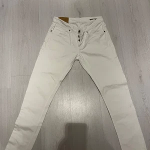Vita jeansbyxor ifrån dondup  - Snygga vita jeans ifrån dondup. Byxorna har en klassisk femficksdesign och en diskret logga baktill.