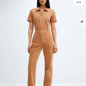Beige jumpsuit med dragkedja - Trendig beige jumpsuit med korta ärmar och dragkedja framtill. Den har en klassisk krage och raka ben, perfekt för en stilren look.