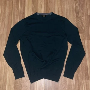 Grön tröja från Massimo Dutti - Snygg grön tröja från Massimo Dutti i storlek L. Tröjan är långärmad och har en klassisk rund halsringning. Perfekt för en stilren look.
