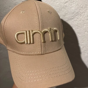 Beige keps från Aimn - Snygg beige keps från Aimn. Perfekt keps till ditt barn ute en fin sommardag. Justerbar passform för optimal komfort. Aldrig använd innan, helt nytt skick. Nypris 199kr men jag säljer för 99kr. Kontakta mig för mer info eller bilder!