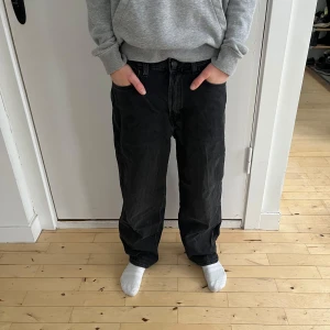Svarta baggy jeans från H&M - Säljer ett par svarta baggy jeans från H&M i storlek EUR 158. Jeansen har justerbar midja och är designade med en lös passform för en avslappnad stil. Perfekta för vardagligt bruk och för en modern look.  Personen på bilderna är 160 cm lång, 12 år gammal och har en smal/normal kroppsbyggnad.  Skick: Mycket bra begagnat skick med minimala tecken på användning.  Nypris: 250 SEK