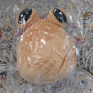 Beige grodformad kudde - Mjuk och gosig kudde i form av en groda med stora svarta ögon. Perfekt för att dekorera sängen eller soffan med en lekfull touch.