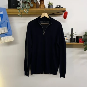 Svart merinoulltröja från Matinique - Snygg svart tröja i 100% merinoull från Matinique. Tröjan har en dragkedja hela vägen och en stilren design som passar perfekt för kyligare dagar. Den är långärmad och har en klassisk passform.