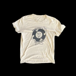 Beige t-shirt med tryck från nudie jeans - Beige t-shirt med tryck från nudie jeans. Den är i strl M och är använd fåtal gånger. Riktigt fet till sommaren med bra passform. Nypris 799 kr. Vårt pris 399 kr.                                            Mvh Distinguished Gentlemens Club. 🎩