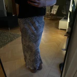 Svart/ beige långkjol med zebramönster - Snygg långkjol i svart/ beige zebramönster. Köpt i somras och endast använd en gång💖