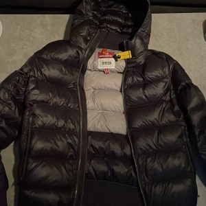 Svart dunjacka från Parajumpers - Säljer en svart dunjacka från Parajumper. I princip ny då jag inte använt den mycket och den har inga skavanker alls ser super bra ut och clean. Grymt snygg och varm nu under dessa kalla dagar. Säljs då jag köpt en ny och inte är i behov av den mer. Nypris cirka 5-6000kr. Säljer för 1900 vid snabb affär. Storlek S passar också lite mindre M. 