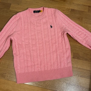 Rosa stickad tröja från Ralph Lauren - Säljer en snygg rosa stickad tröja från Ralph Lauren. Tröjan passar bra dock så den har lite korta armar. Tröjan har bara använts 1 gång och är i perfekt skick. 