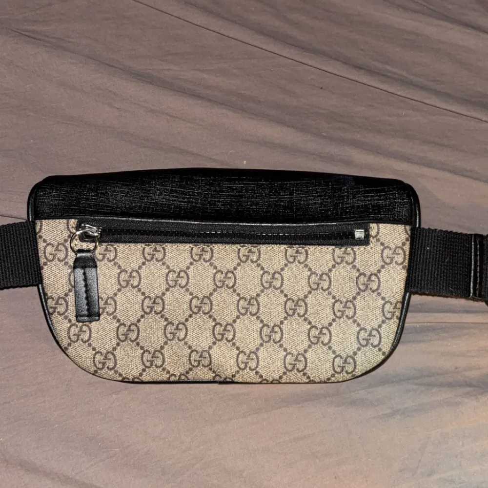Snygg magväska från Gucci med det klassiska GG-mönstret. Väskan har en justerbar rem och flera dragkedjeförsedda fack för säker förvaring. Perfekt för att hålla dina saker organiserade och lättillgängliga.. Laukut & Käsilaukut.