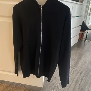 Zip hoodie - Säljer en stilren svart kofta med dragkedja. Perfekt att matcha med olika outfits. Koftan har långa ärmar och en bekväm passform.