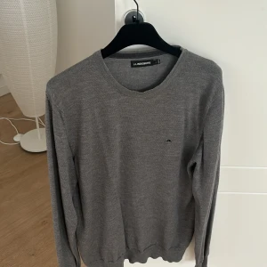 Grå tröja från J.Lindeberg - Säljer en stilren grå tröja från J.Lindeberg. Tröjan har en klassisk design med rund hals och långa ärmar. Perfekt för en avslappnad men ändå snygg look. Observera att det är ett litet hål som knaptt synd på höger axel som du lätt kan sy igen. Storlek L och priset är inte hugget i sten och hör av er vid frågor!