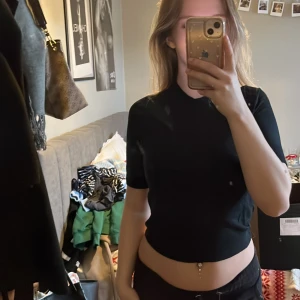 Svart tröja från lager - Säljer en stilren svart tröja från Lager. Tröjan har en ribbad krage och korta ärmar, perfekt för en minimalistisk look. Passar bra till både jeans och kjol. Hör av dig vid intresse!