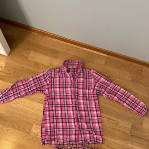 Rutig pyjamas  - Ett rutigt pyjamas set som är mörkblått, rosa och vitt. Skönt material och nästan oanvänd. Jätte fin och snygg till ett pyjamasparty.