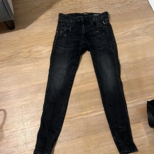Svarta jeans från Replay - Snygga svarta Replay jeans med en slim passform. De har en klassisk femficksdesign och diskreta slitningar för en cool look. Perfekta för en stilren outfit.