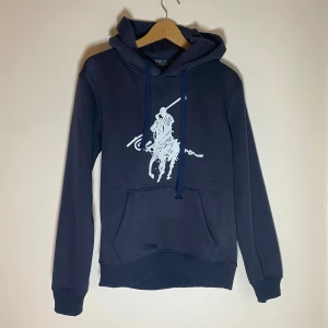 Ralph Lauren hoodie - 	FÖRSTA TILL 600 ELLER BÄSTA ERBJUDANDET INNAN LÖRDAG VINNER! ✅•	Marinblå Ralph Lauren hoodie 	•	Storlek: M 	•	Klassisk design med broderad logotyp på bröstet 	•	Färgen är marinblå, ser svart ut på bilden 	•	I mycket bra skick!