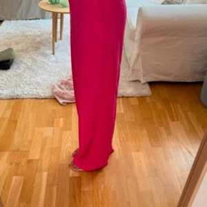 Rosa byxor - Snygga rosa byxor med hög midja och rak passform. Perfekta för att liva upp garderoben med en färgklick. Byxorna har en stilren design utan mönster eller extra detaljer.