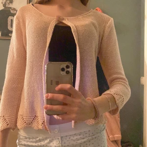 Rosa stickad kofta från Baraka & Ziggy - Säljer en söt rosa stickad kofta från Baraka & Ziggy. Koftan har trekvartsärmar och en fin öppen design framtill. Perfekt för lager-på-lager och ger en romantisk touch till din outfit. 🌸 den är lite trasig i kragen men det är lagat så det syns inte när man har på sig den.❤️