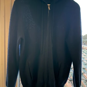 Soft goat hoodie I  100% kashmir med dragkedja. - Säljer en mörkblå stickad hoodie  i 100% kashmir med dragkedja från Soft goat. Tröan är lagad på armen hos sömerska, se bild 3,  men inget som syns. 