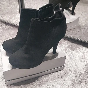 Svarta stövletter med klack - Snygga svarta stövletter från Benetton i mocka med dragkedja på sidan. Perfekta för en stilren look med en bekväm klack.