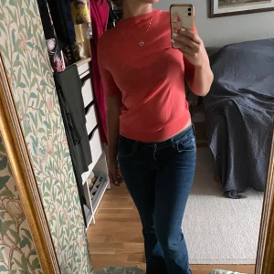 Röd kortärmad topp - Säljer en snygg röd kortärmad topp med rund halsringning. Perfekt för en casual look eller att klä upp med accessoarer. Passar bra till jeans eller kjol.