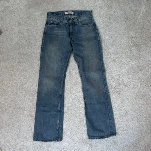 Blå jeans från Levi's - Säljer ett par klassiska blå straight leg jeans från Levi's i modellen 506. Mycket snygg tvätt och femficksdesign med knapp och dragkedja framtill. Storlek W28 L32 men passar mig som vanligtvis har storlek W25 och är 165cm lång. 