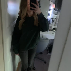 Mörkgrön sweatshirt från Junkyard - Säljer en stilren mörkgrön sweatshirt från Junkyard. Tröjan har en klassisk rund hals och långa ärmar, perfekt för en avslappnad look. Materialet känns mjukt och bekvämt, idealiskt för kyligare dagar. Är i nyskick!😍