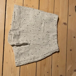 Vit stickad kjol från Zara - Snygg vit stickad kjol från Zara i en bekväm passform. Kjolen har en diskret textur och är perfekt för en stilren look. Den är enkel att matcha med olika toppar och accessoarer. Shorts under .