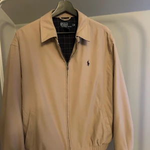 Beige jacka från Ralph Lauren - Snygg beige harrington jacka från ralph lauren, jättebra skick. Storlek M men passar båda M och S. Nypris på denhär är över 2000kr 🤩 kom med frågor eller prisförslag!