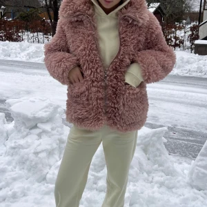 Rosa teddyjacka med dragkedja - Mysig rosa teddyjacka med dragkedja och hög krage. Jackan har långa ärmar och två praktiska fickor framtill.