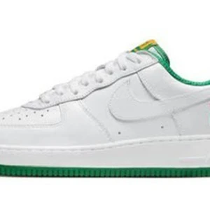 Nike Air Force 1 Low Retro West Indies - Snygga Nike Air Force 1 Low Retro West Indies med vit läderöverdel och gröna detaljer. Skorna har en unik West Indies-design med broderad text och palm på hälen. Perfekta för en stilren look med en touch av karibisk inspiration. Helt nya, aldrig använda. Köpta på SNKRS.