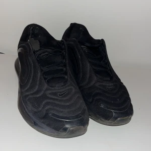 Nike air max 720 - Säljer ett par svarta Nike sneakers med en modern design och vågformade detaljer. Skorna har en diskret Nike-logga på sidan och är perfekta för en stilren look. Bubblan är sönder därav priset. Nypris ca 3000