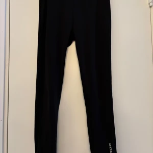 Svarta träningsleggings från SOC storlek 158/164 - Snygga svarta träningsleggings från SOC, perfekta för gymmet eller löprundan. De har en tight passform och är tillverkade i ett stretchigt material för optimal rörelsefrihet. Diskret logga på benet.