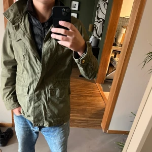 Grön fieldjacka från Dobber - Säljer en helt ny Fieldjacket från Dobber i storlek medium. Jackan har en dragkedja framtill och flera praktiska fickor. Perfekt för höst och vår med sin stilrena design och bekväma passform. Hör av er vid frågor!👍