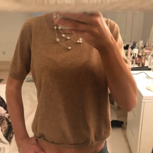 Brun kortärmad tröja - Säljer en stilren brun kortärmad tröja i mjukt material. Perfekt för en avslappnad look. Passar bra till jeans eller kjol.
