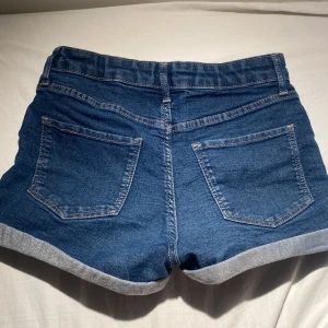 Blå jeansshorts med uppvikta ben - Snygga blåa jeansshorts men klassisk bakfickor, dem är mid waisted och har inga skandaler 💗 super bra för sommaren eller annat! 